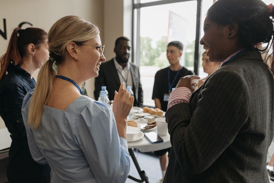 Attendees with name badges talk over coffee during a break.