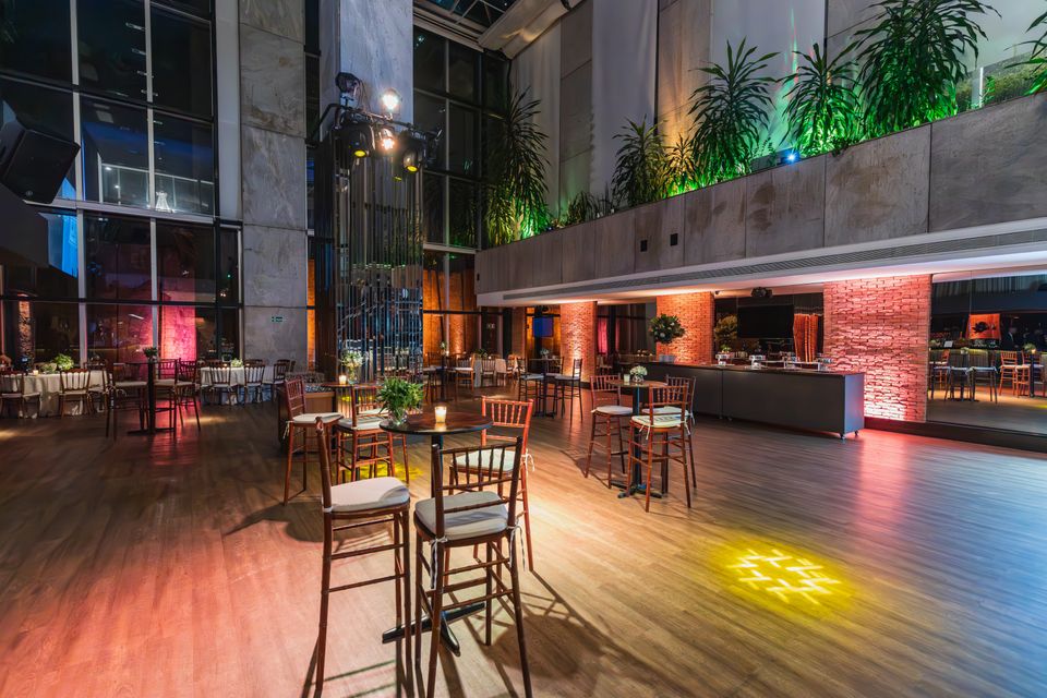 A warmly lit event space set with round tables before guests arrive.